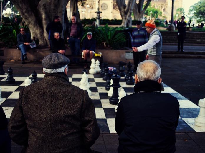 Et billede af folk, der spiller brætspil et offentligt sted. 